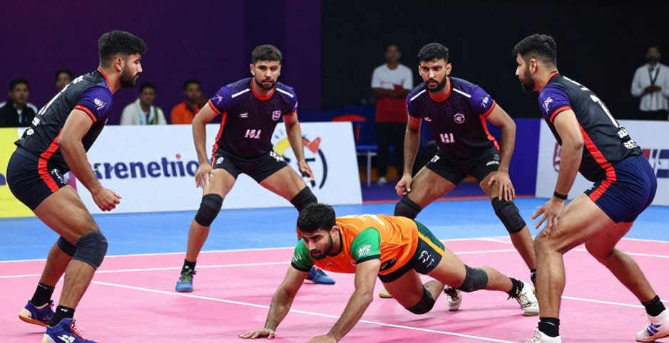 কমনওয়েলথ কাবাডি চ্যাম্পিয়নশিপ ২০২৬-এর লোগো: চার ডিফেন্ডারের মাঝে এক রেইডার, আর তার বাইরের হিসাব